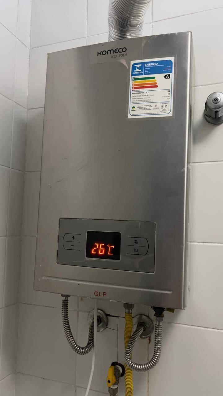 Aquecedor de água a gás instalado e ligado, marcando 26 graus